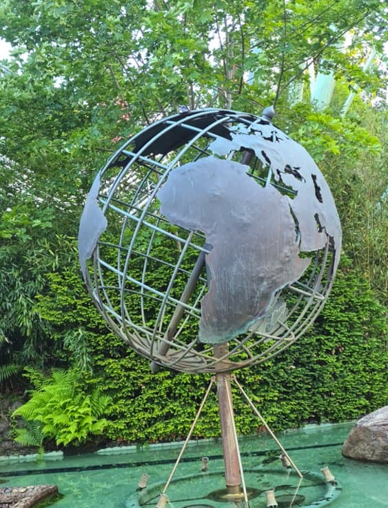 Metal globe sculpture in a garden